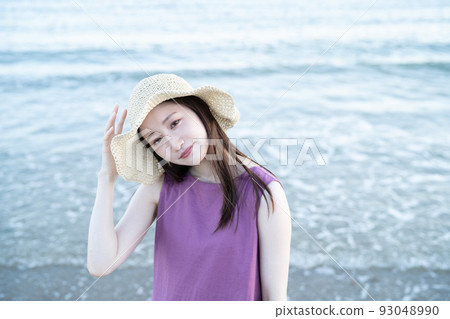 戴草帽的年輕女子在沙灘上玩耍 93048990