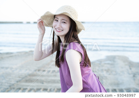 戴草帽的年輕女子在沙灘上玩耍 93048997