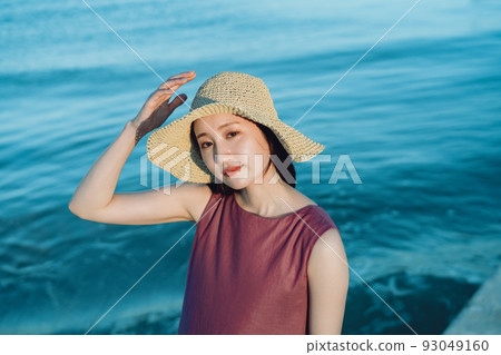 Young woman in straw hat playing on the beach Young woman in straw hat playing on the beach 93049160