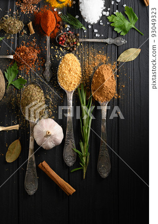 Colorful various herbs and spices for cooking on dark wooden rustic background Colorful various herbs and spices for cooking on dark wooden rustic background 93049323