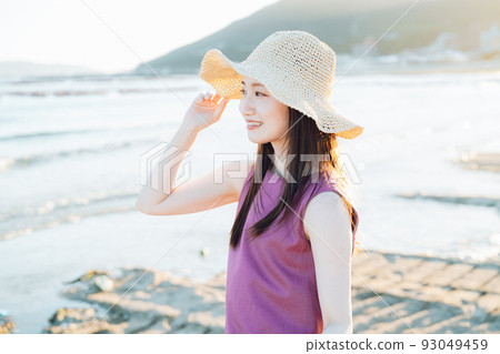 戴草帽的年輕女子在沙灘上玩耍 93049459
