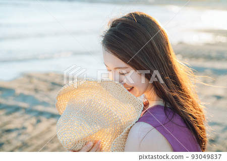 戴草帽的年輕女子在沙灘上玩耍 戴草帽的年輕女子在沙灘上玩耍 93049837