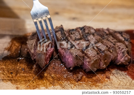 Medium rare meat on wooden plate Medium rare meat on wooden plate 93050257
