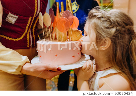 girl biting festive birthday cake kids party girl biting festive birthday cake kids party 93050424