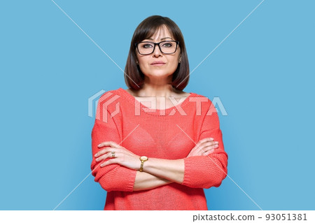 Serious confident middle aged woman on blue background 93051381