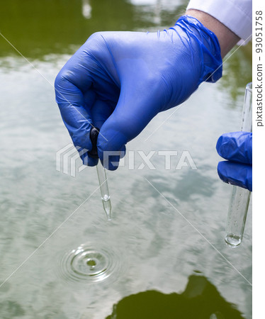 Water sample. Checking the condition of rivers or natural lakes. Water test for chemicals, bacteria, harmful substances, radiation. Collection of material in a test tube for further research. 93051758