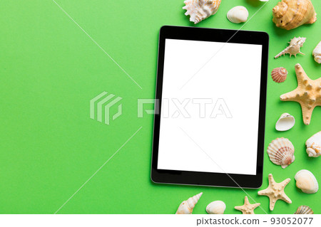Flat lay composition with tablet and beach accessories on colored background. Tablet computer with blank screen mock up with copy space 93052077