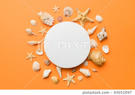 Summer time concept with blank greeting card and blank white paper on colored background. Seashells from ocean shore in the shape of frame separated with space for text top view Summer time concept with blank greeting card and blank white paper on colored background. Seashells from ocean shore in the shape of frame separated with space for text top view 93052097