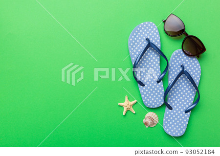 Summer travel concept. Flip flops, sunglasses and starfish on white. Top view on colored background 93052184