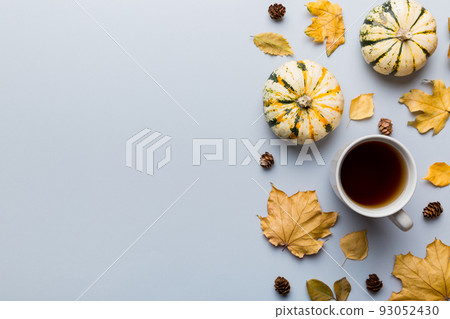 Flat lay composition with colorful Autumn cup of coffee and leaves on a color background. top view 93052430