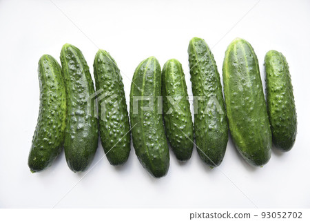 Green juicy cucumbers on a white background. Green juicy cucumbers on a white background. 93052702