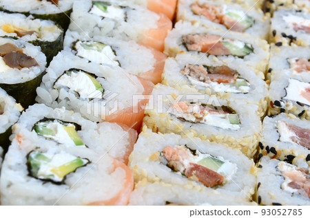 Close-up of a lot of sushi rolls with different fillings. Macro shot of cooked classic Japanese food. Background image Close-up of a lot of sushi rolls with different fillings. Macro shot of cooked classic Japanese food. Background image 93052785