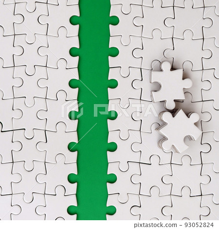 The green path is laid on the platform of a white folded jigsaw puzzle. The missing elements of the puzzle are stacked nearby. Texture image with space for text The green path is laid on the platform of a white folded jigsaw puzzle. The missing elements of the puzzle are stacked nearby. Texture image with space for text 93052824