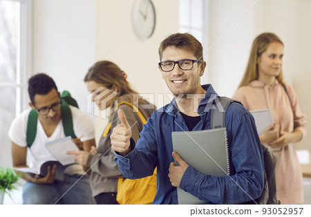 Happy college or university student who has achieved success in studies shows a thumbs up Happy college or university student who has achieved success in studies shows a thumbs up 93052957