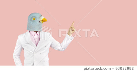 Strange guy in funny pigeon mask pointing his finger at copy space on pink banner background Strange guy in funny pigeon mask pointing his finger at copy space on pink banner background 93052998