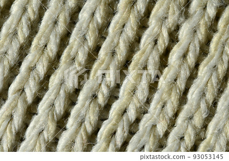 Fabric texture of a soft yellow knitted sweater. Macro image of the structure of bindings in yarns 93053145