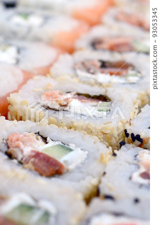 Close-up of a lot of sushi rolls with different fillings. Macro shot of cooked classic Japanese food. Background image Close-up of a lot of sushi rolls with different fillings. Macro shot of cooked classic Japanese food. Background image 93053345