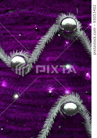 Texture of the wall decorated with New Year's fluffy ribbons and decorations in the form of glossy balls Texture of the wall decorated with New Year's fluffy ribbons and decorations in the form of glossy balls 93053402