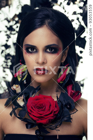 pretty brunette woman with rose jewelry, black and red, bright make up like a vampire closeup red lips, halloween concept 93053559