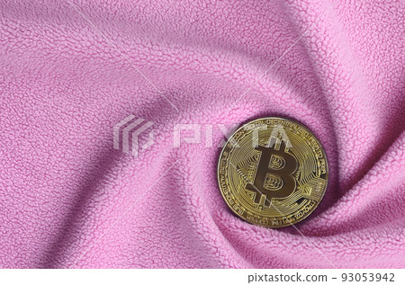 The golden bitcoin lies on a blanket made of soft and fluffy light pink fleece fabric with a large number of relief folds. The shape of the folds resembles a fan from a video card cooler 93053942