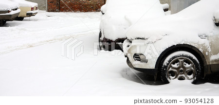 Fragment of the car under a layer of snow after a heavy snowfall. The body of the car is covered with white snow Fragment of the car under a layer of snow after a heavy snowfall. The body of the car is covered with white snow 93054128