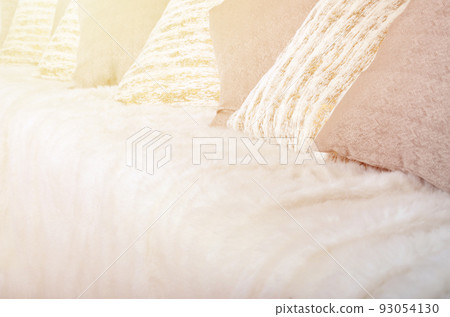Many pillows lie on the couch, which is covered with a large plush veil Many pillows lie on the couch, which is covered with a large plush veil 93054130