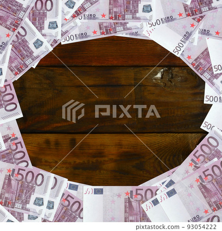 A lot of purple denominations worth 500 euros lie on a wooden surface with an empty pad in the middle of the image. Copy space for text A lot of purple denominations worth 500 euros lie on a wooden surface with an empty pad in the middle of the image. Copy space for text 93054222