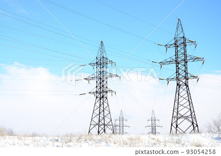 Towers of power lines in the winter field. Electrical equipment Towers of power lines in the winter field. Electrical equipment 93054258