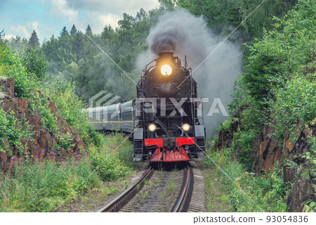 Retro steam train approaches to the platform. 93054836