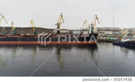 Flight over group of ships on berths of Murmansk seaport waiting for coal loading Flight over group of ships on berths of Murmansk seaport waiting for coal loading 93057438