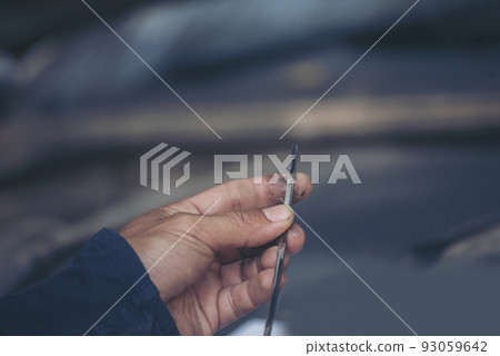 Car Mechanic man hand checking dipstick engine oil car mechanical on site service. Close up hand man check engine oil level Locate dipstick, wipe clean, check dipstick level before fill up engine oil Car Mechanic man hand checking dipstick engine oil car mechanical on site service. Close up hand man check engine oil level Locate dipstick, wipe clean, check dipstick level before fill up engine oil 93059642