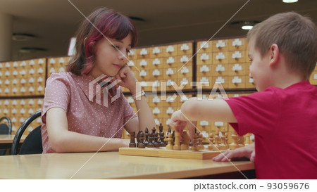 4K. Children play chess in the library 4K. Children play chess in the library 93059676