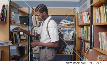 4K. An African-American man reads a book in the library 4K. An African-American man reads a book in the library 93059713