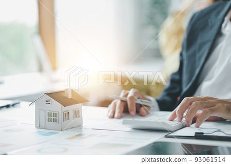 Cropped shot of estate agent using calculator calculate for contract to buy or sell house, mortgage loan or home insurance in the office. 93061514