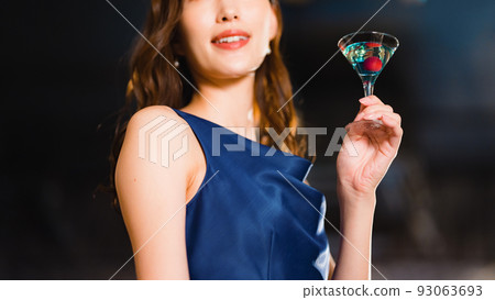 Beautiful woman drinking a cocktail at the bar 93063693
