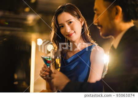 A beautiful woman drinking with a bearded man in his 40s 93063874