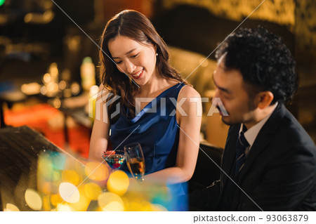 A beautiful woman drinking with a bearded man in his 40s 93063879