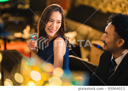 A beautiful woman drinking with a bearded man in his 40s A beautiful woman drinking with a bearded man in his 40s 93064013