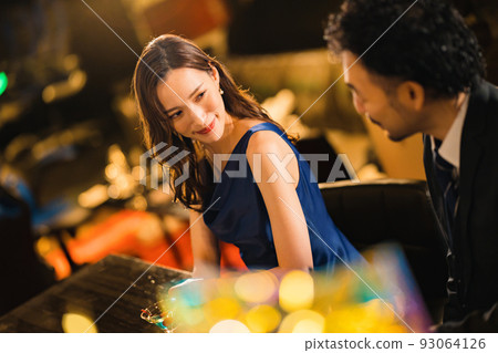 A beautiful woman drinking with a bearded man in his 40s 93064126