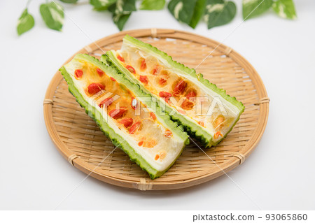 Cross section of bitter gourd with red seeds 93065860