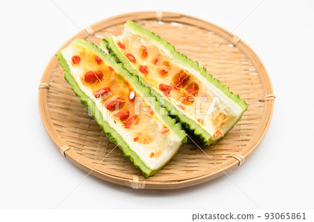 Cross section of bitter gourd with red seeds 93065861