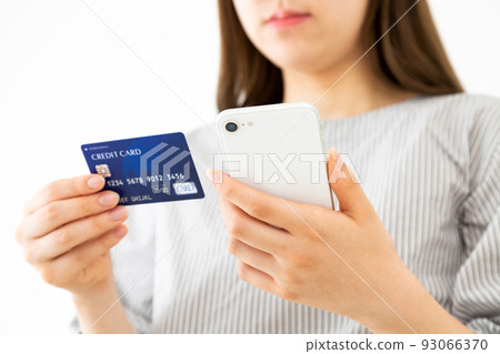 Young woman with credit card and smartphone Young woman with credit card and smartphone 93066370