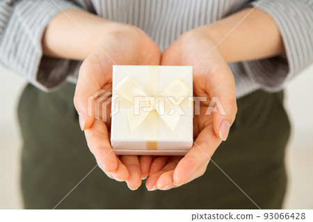 Young woman with a small gift box of presents 93066428