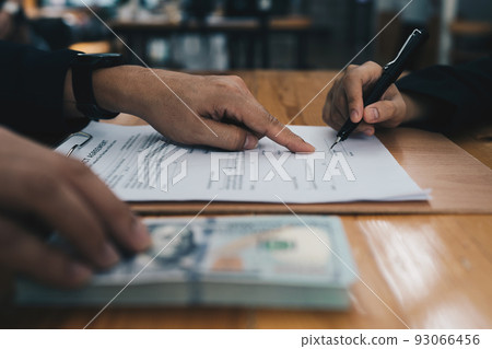 Partner give bribe money in envelope to another businessman and pointing at sign permit contract. Corruption and Anti Bribery concept. Partner give bribe money in envelope to another businessman and pointing at sign permit contract. Corruption and Anti Bribery concept. 93066456