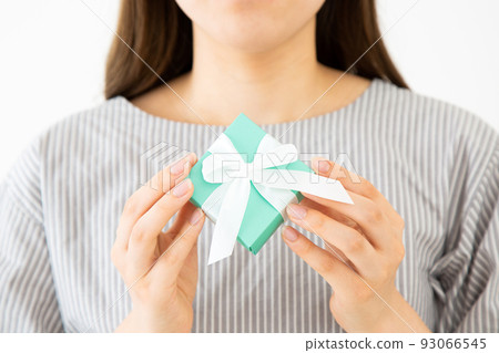 Young woman with a small gift box of presents Young woman with a small gift box of presents 93066545