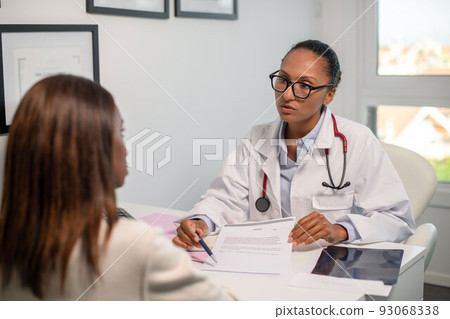 Confident doctor showing agreement to female patient in clinic Confident doctor showing agreement to female patient in clinic 93068338