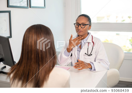 African American doctor talking to female patient in her office 93068439