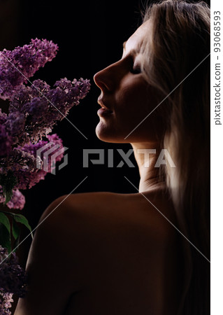 profile of a beautiful blonde woman with a bare shoulder and a bouquet of lilacs profile of a beautiful blonde woman with a bare shoulder and a bouquet of lilacs 93068593