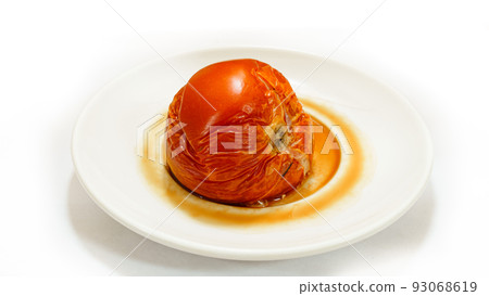 the tomato on the white plate spoils. the decay of vegetables. the tomato on the white plate spoils. the decay of vegetables. 93068619