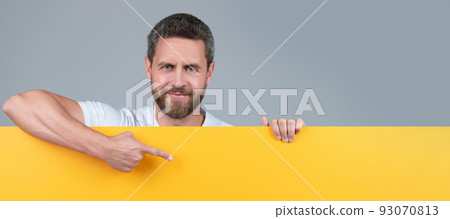 presenting novelty information. male behind yellow paper. for your marketing design. Man face portrait, banner with copy space. 93070813